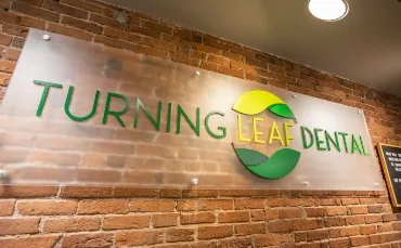 The Turning Leaf Dental sign on a brick wall